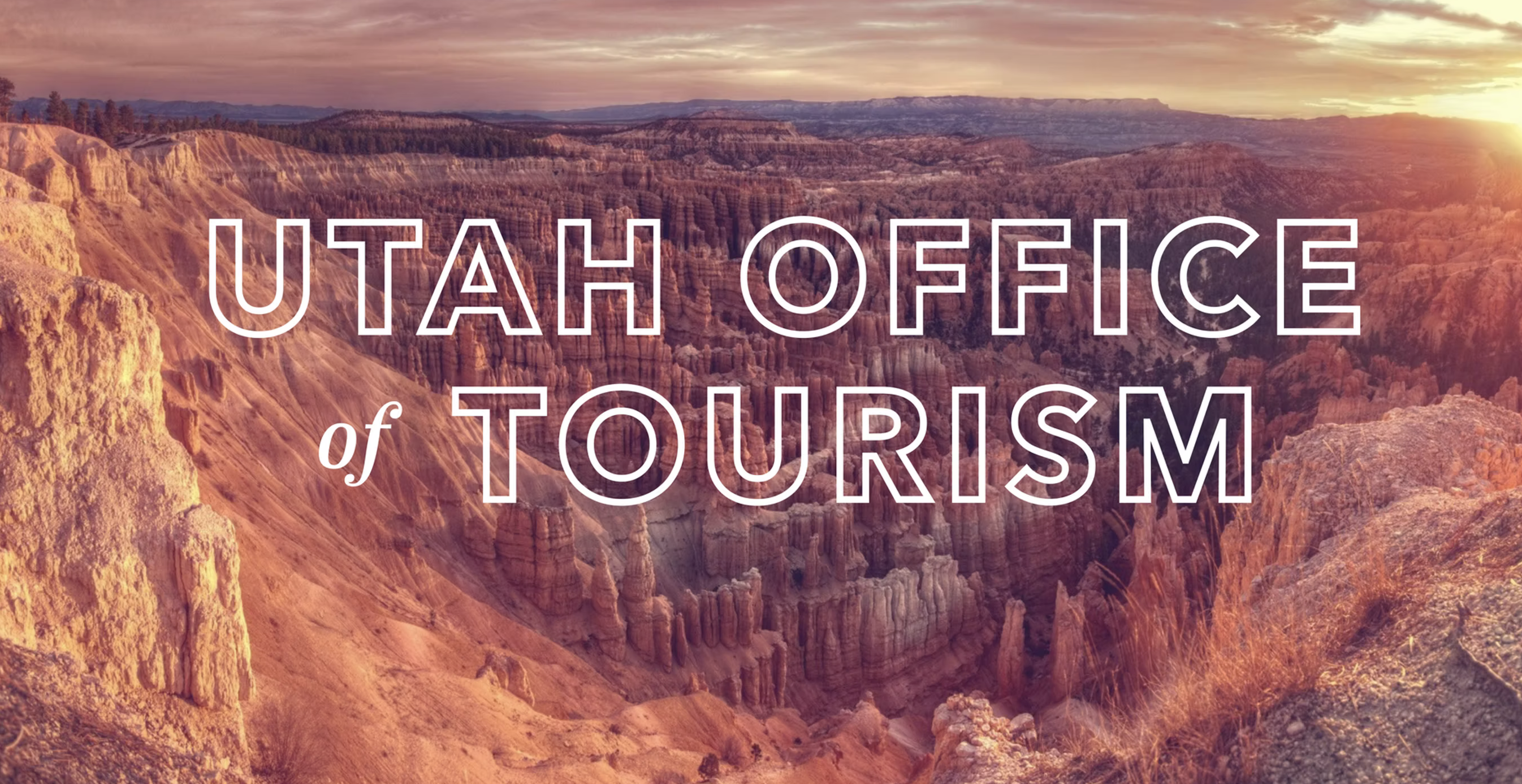 Travelers watching sunset through a Utah sandstone arch.